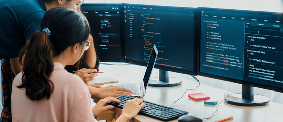 Group of professional web developer discuss about data analysis while computer screen show computer code at modern office. Close up. Digital engineering and web development concept. Burgeoning.