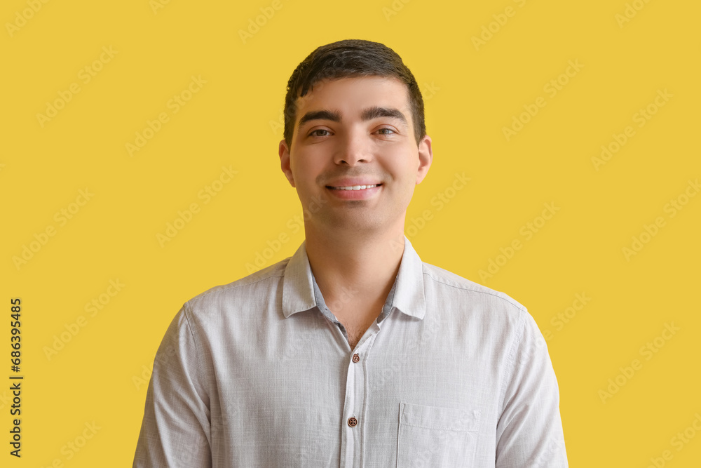 Happy young man on yellow background, closeup