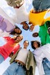 © Xavier Lorenzo - Low angle view vertical photo of young diverse women standing together in circle hugging each other and smiling at camera outdoors