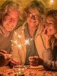 © Daniel - group of people and family celebrating some party or new year together at the terrace of the home - four sparklers at the middle together