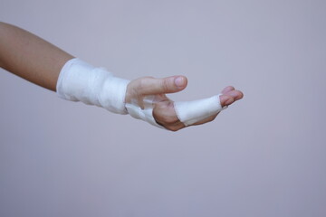 Wall Mural - Asian and African male hands with elastic bandages on white background. Wrist wound, bandage, hand wound, painkiller