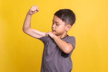 asian little boy showing bicep muscle with confident expression