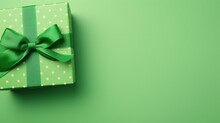 St Patrick's Day Concept. Top View Of Green Giftbox With Polka Dot Pattern And Ribbon On Green Background With Copy Space