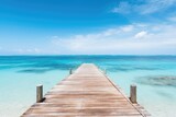 Fototapeta Most - A wooden pier or jetty heading toward the horizon on a crystal clear sea water beach