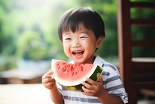 Cute Little Asian Boy Eating A Fresh Slice Of Watermelon
