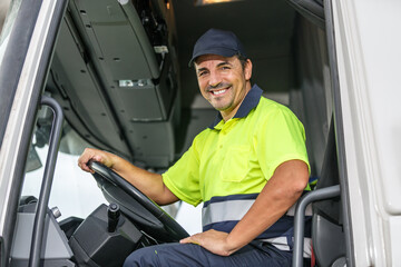 Cheerful male driver sitting in truck while looking at camera