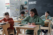 © Mediaphotos - Group of school children sitting at their desks and studying in the classroom at school