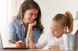 © lordn - Mother and daughter learning together at home, sitting at the desk in front of a computer. Back to school