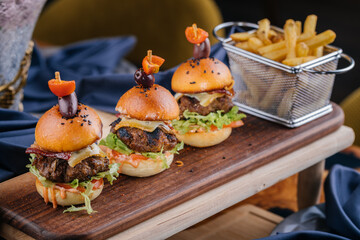 Beef Slider or mini sandwich served on wooden with french fries bucket board isolated on table top view of arabic fastfood