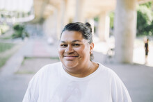 Portrait of smiling oversized woman wearing white t-shirt