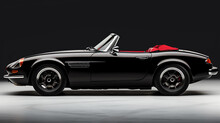 A Black Convertible Car With A Red Top