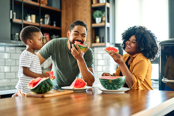 child family kitchen food boy son father mother watermelon fruit slice summer organic meal fun preparing healthy diet eating home black