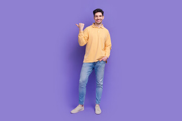 Sticker - Full length photo of handsome young guy point promo empty space wear trendy yellow garment isolated on violet color background