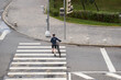 © nuclear_lily - Man crosses the road at a pedestrian crossing and carries a bicycle next to him. View from above.