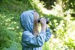 Cute little girl exploring nature looking through binoculars. Child playing outdoors. Kids travel, adventure and bird watching concept.	