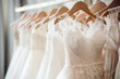 Elegant wedding dresses hanging on hangers in shop. Bridal dress in wedding boutique salon