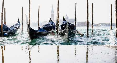 Wall Mural - high waves splashing along gondolas in Venice Italy