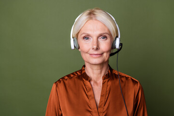 Sticker - Portrait of good mood nice senior person with blond hair wear blouse speak with client by headset isolated on khaki color background