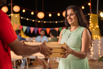 happy young girl receiving pizza boxes from delivery person for evening party celebration - concept of 2024 new year celebration, pizza treat and fast food service