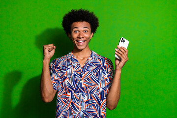 Poster - Photo of excited lucky man dressed print shirt winning game modern gadget isolated green color background