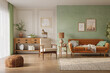 © Василь Чейпеш - Orange sofa in cozy living room interior with pastel green wall and wood furniture. Wall mockup, 3d rendering