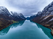 symmetrical erial view over blue mountain lake in norwegian mountains with reflections