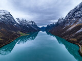 Fototapeta  - symmetrical erial view over blue mountain lake in norwegian mountains with reflections