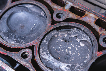 Wall Mural - Close-up of a damaged piston of an internal combustion engine with carbon deposits in the cylinder block of a faulty engine