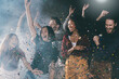 © gstockstudio - Group of happy young people dancing and throwing confetti while having fun in night club together