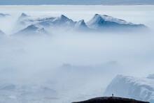 Lone Person Overlooks Icebergs At The Ilulissat Icefjord; Ilulissat, Greenland