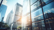 © MP Studio - Low-angle view of towering skyscrapers with reflective glass facades against a backdrop of blue sky and sunlight in an urban cityscape.