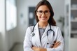 © Elena - a portrait of a smiling female doctor wearing glasses looking to camera