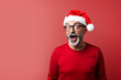 © tiena - Surprised man in red a christmas hat. AI generated