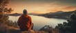 Hooded man watching sunset at calm lake in rural area Copy space image Place for adding text or design