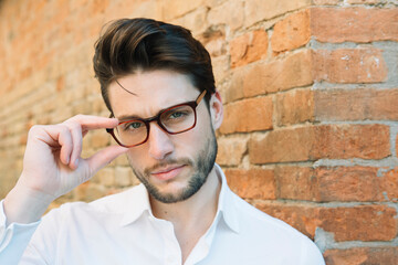 Wall Mural - Portrait of a man wearing glasses at brick wall