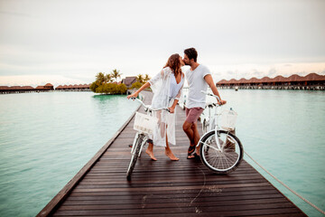 Poster - Couple with bicycles kissing on a jetty in the sea, Maguhdhuvaa Island, Gaafu Dhaalu Atoll, Maldives