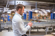 © tunedin - Man in factory looking at cell phone