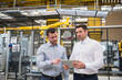 © tunedin - Two men with tablet talking in factory shop floor