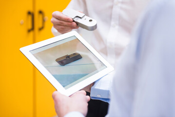 close-up of two men with tablet and product in factory