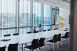 © tunedin - Germany, Berlin, businessman sitting in conference room with feet up looking out of the window