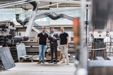 Fototapeta  - Three men standing and talking on factory shop floor