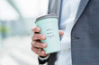 © tunedin - Close-up of businessman holding recycable takeaway coffee cup