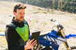 © tunedin - Portrait of motocross driver looking at tablet