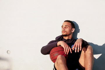 Wall Mural - Young man with basketball having a break