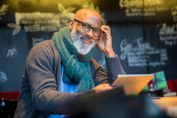 Wall Mural - Portrait of smiling man with tablet in a coffee shop