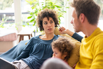 Wall Mural - Family lying on couch watching movie on theit tablet