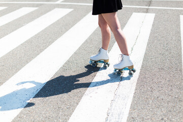 Wall Mural - Young woman with roller skates on zebra crossing, partial view