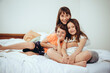© tunedin - Happy mother in bed with her daughter and son