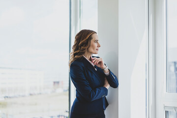 Mature businesswoman looking out of window in office