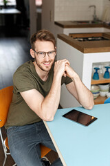 Wall Mural - Portrait of smiling man with tablet in kitchen at home